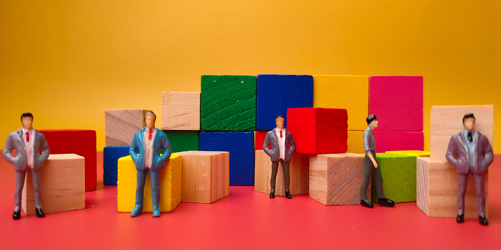 Picture of people standing around colored wooden blocks.